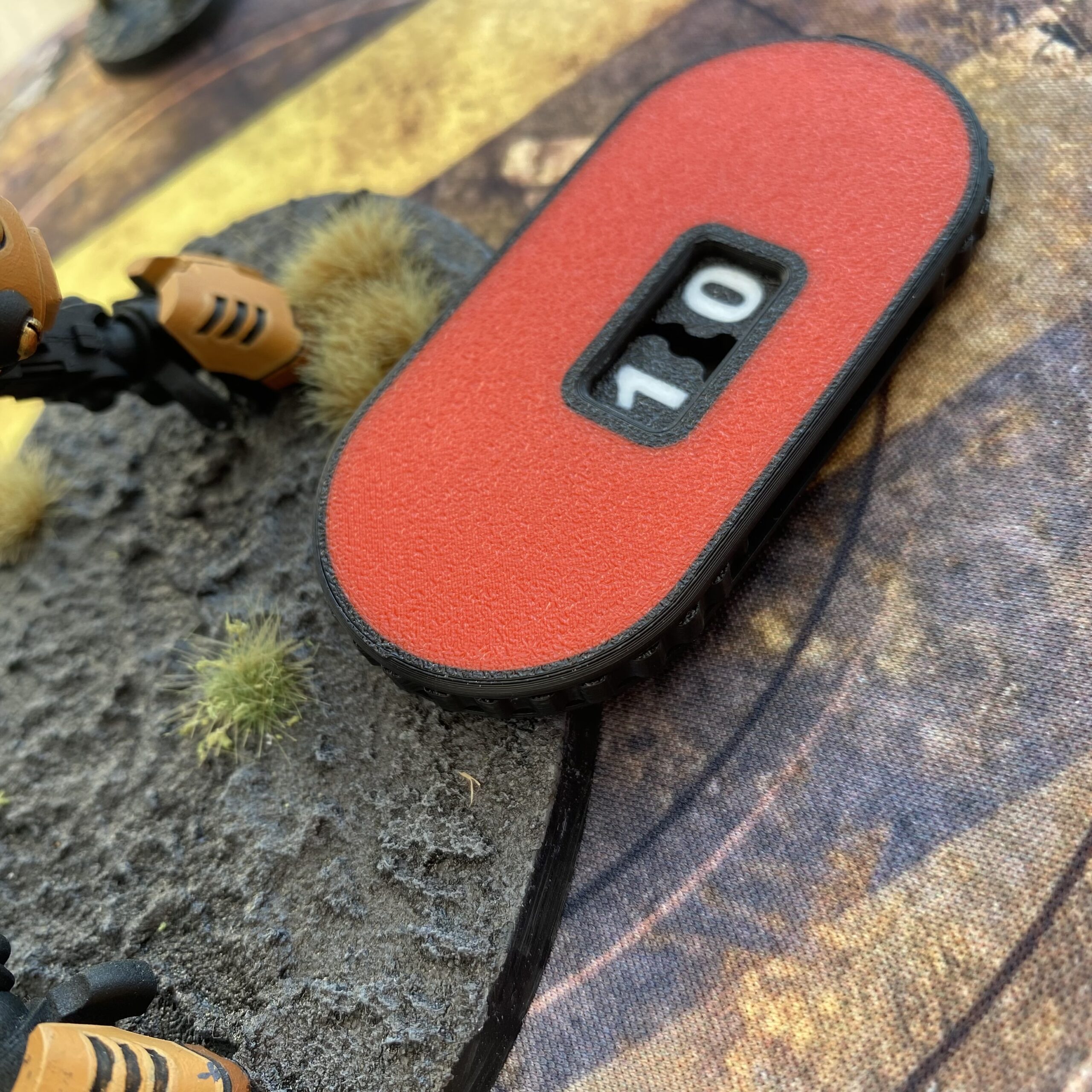 Red dial counter on a tabletop battle mat